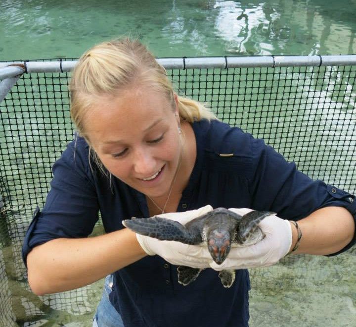 Tina smiling holding a turtle